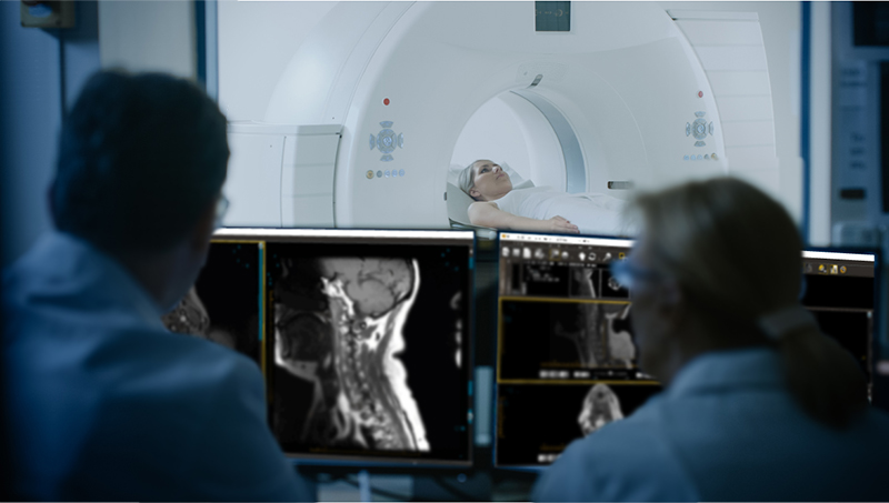 In Medical Laboratory, Patient Undergoes MRI under Supervision of Doctor and Radiologist in Control Room who view the results of the procedure in the ProtonPACS software